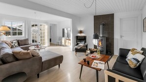 Una sala moderna con chimenea, un sofá, una mesa de centro y un televisor.