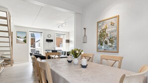 Un espace repas avec une longue table, des chaises et une carte accrochée au mur.