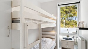 Une chambre avec un lit superposé, un bureau et une fenêtre.