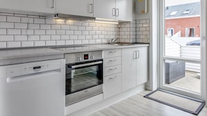 A modern kitchen with white cabinets, a Bosch oven, and a window to the outside. - "Raine" - 2.3km from the sea by Interhome (Rømø)