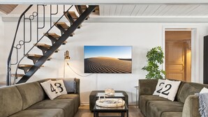 A living room with two sofas, a coffee table, a TV, and a staircase. - "Dana" - 525m from the sea by Interhome (Tranekær)