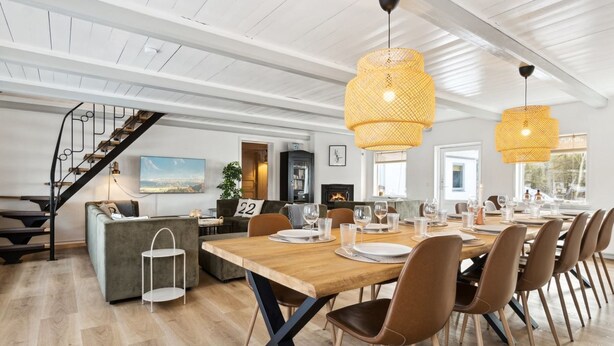 A spacious dining area with a long wooden table, multiple chairs, and two large woven pendant lights. A staircase with a metal railing is visible in the background. - "Dana" - 525m from the sea by Interhome (Tranekær)
