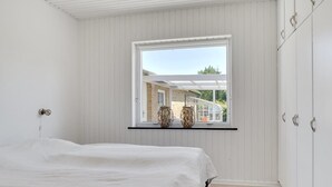 A bedroom with a bed, a window, and a wardrobe.