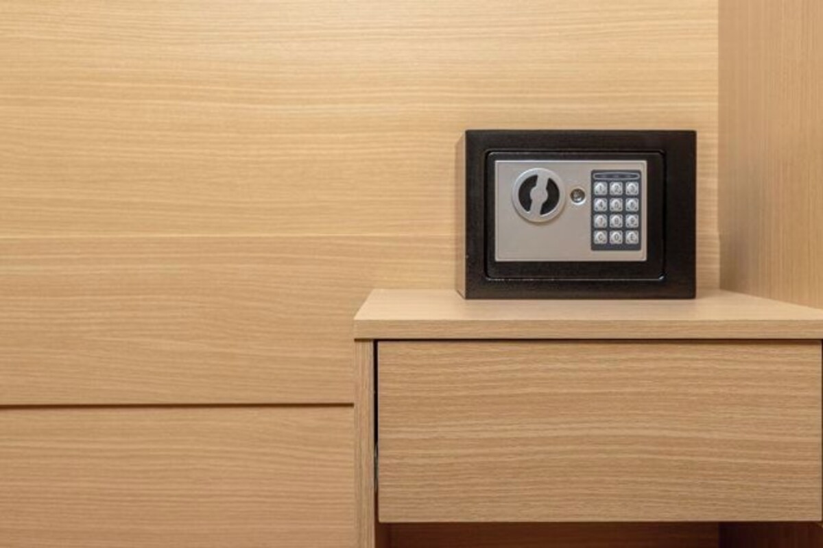 A safe with a keypad on a wooden cabinet.