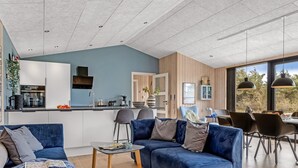 Een moderne woonruimte met keuken, eethoek en zithoek.