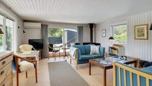 Een gezellige, goed verlichte kamer met televisie, bank en eethoek.