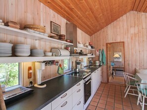 Een koelkast, een oven, een vaatwasser, kookgerei, borden en bestek