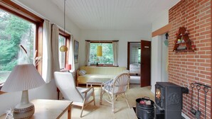 Une pièce confortable avec un lit, une table avec une lampe, une chaise, une cheminée et une vue sur l’extérieur.