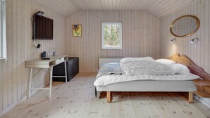 A bedroom with a bed, a desk, a radiator, a window, and a mirror. - "Aneline" - 700m from the sea by Interhome (Saltum)