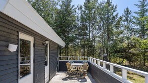 A wooden deck with a table and chairs, a metal bucket, and a railing. - "Aneline" - 700m from the sea by Interhome (Saltum)