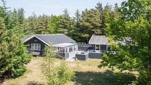 A cabin with a deck and a covered porch, surrounded by trees. - "Aneline" - 700m from the sea by Interhome (Saltum)