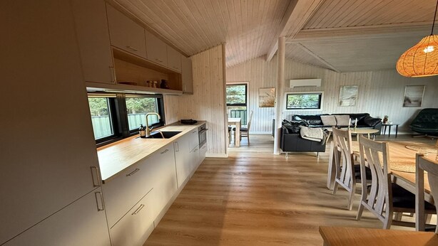 Une cuisine moderne avec des meubles en bois et une grande fenêtre.
