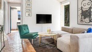 A modern living room with a green chair, a beige sofa, a round coffee table, and a flat-screen TV mounted on the wall. - "Kadife" - 750m from the sea by Interhome (Saltum)