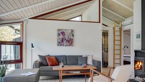 Un salon moderne avec un canapé gris, une table basse en bois et une cheminée.
