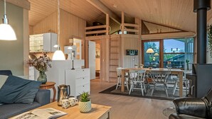A modern interior with wooden beams, a dining area, and a fireplace.