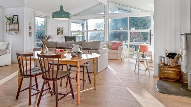 A spacious living room with a high ceiling, a dining area with wooden chairs and a table, and a cozy seating area with a sofa and armchairs. - "Onta" - 900m from the sea by Interhome (Blokhus)