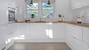 A modern kitchen with white cabinetry, a double sink, and pendant lighting. - "Onta" - 900m from the sea by Interhome (Blokhus)