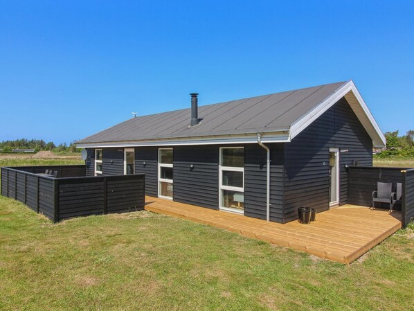 A modern house with a large deck, a covered outdoor area, and a chimney. - "Elenore" - 900m from the sea by Interhome (Løkken)