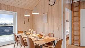 A dining area with a wooden table, chairs, and a view of the water.