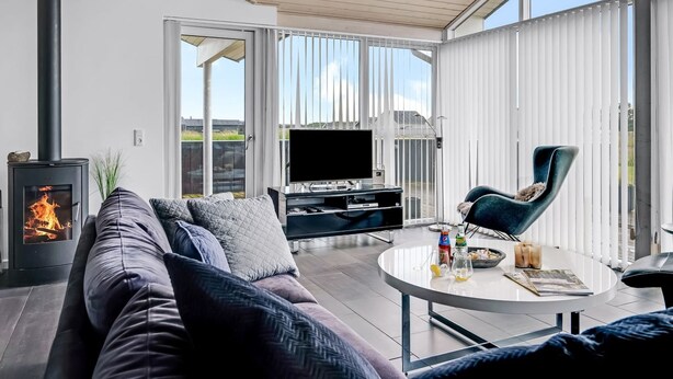 Una sala de estar moderna con un sofá, una mesa de centro, un televisor y una chimenea.