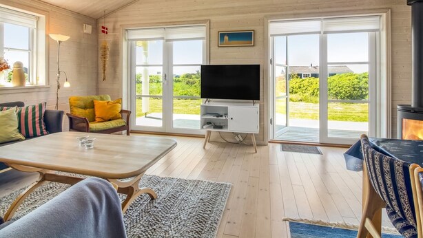 A cozy living room with a wooden ceiling, a flat-screen TV, a sofa, and a dining table. - "Armgard" - 300m from the sea by Interhome (Løkken)