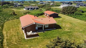 A coastal residential area with houses featuring red roofs and white trim, surrounded by green lawns and a view of the sea. - "Armgard" - 300m from the sea by Interhome (Løkken)