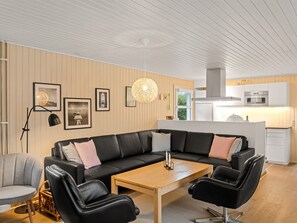A modern living room with a black leather sofa, a wooden coffee table, and a black floor lamp. - "Ingebore" - 700m from the sea by Interhome (Løkken)