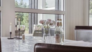 A dining table with candles, a vase with flowers, and a bottle of water. - "Ingebore" - 700m from the sea by Interhome (Løkken)