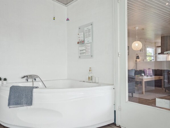A modern bathroom with a freestanding bathtub, a towel, and a glass shower enclosure.