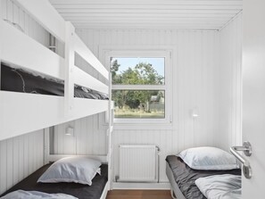 A dormitory room with bunk beds, a window with a view of trees and a house, and a white radiator. - "Ingebore" - 700m from the sea by Interhome (Løkken)
