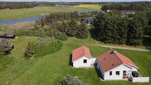 A rural property with two white buildings, a large field, and a body of water. - "Frellef" - 491m from the sea by Interhome (Løkken)