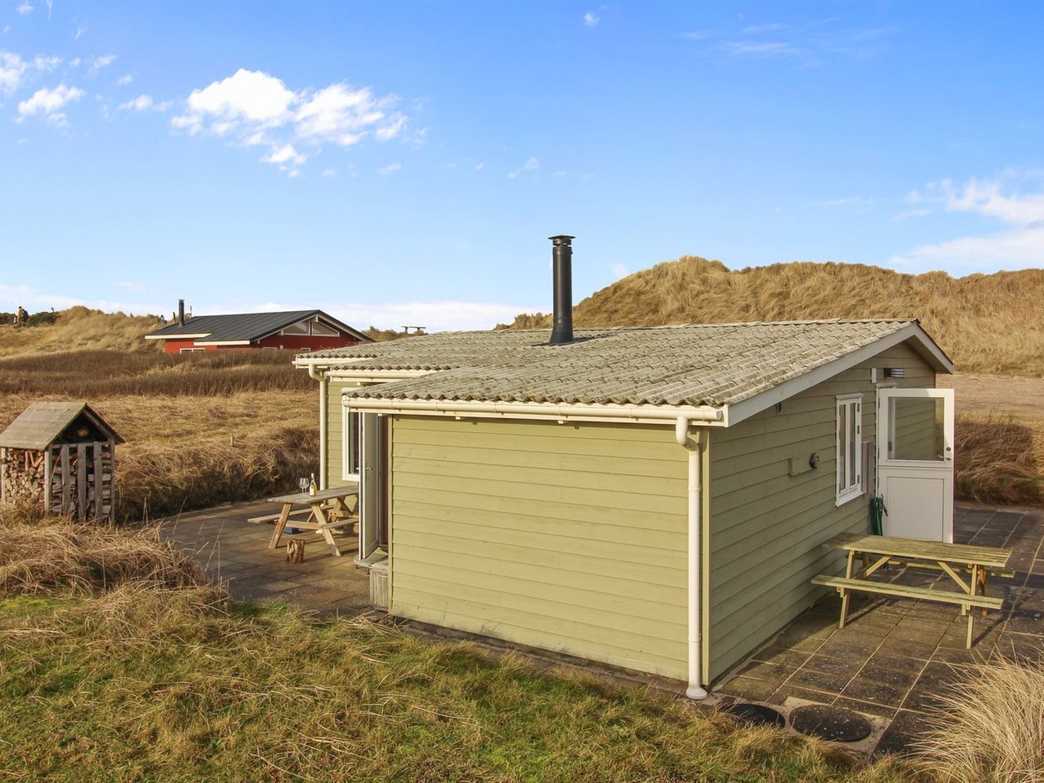 En liten, envåningsbyggnad med ett sluttande tak, en skorsten och en dörr.