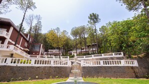 Un patio central con una fuente, rodeado por un muro de piedra y un edificio con balcones.