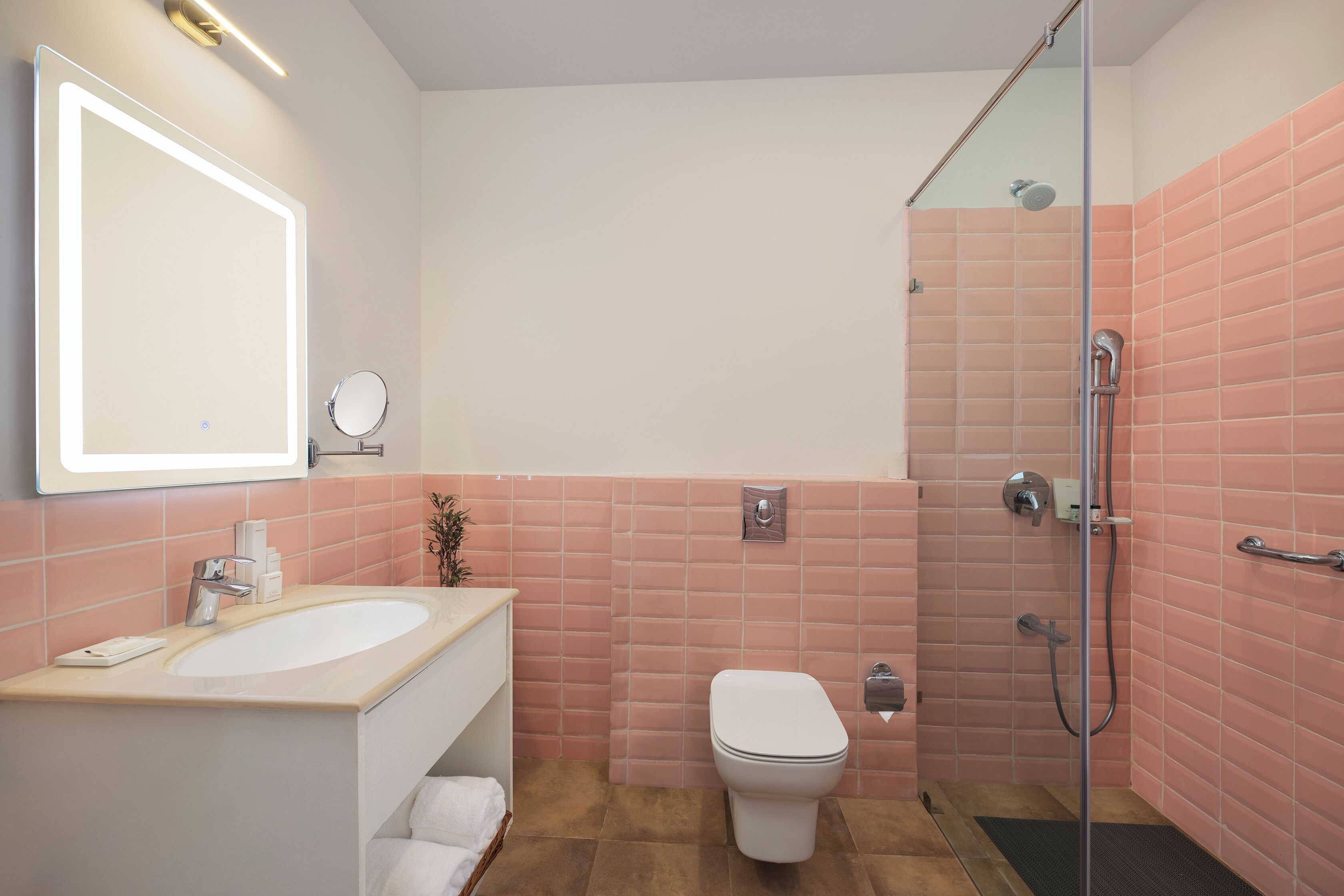 A bathroom with a sink, mirror, toilet, and shower.
