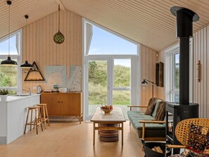 Un salón amplio con un gran ventanal, una mesa de comedor de madera y un sofá.