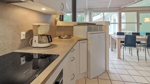 Eine moderne Küche mit Herd, Kaffeemaschine und Kühlschrank.