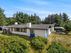 A modern house with a large window, a deck, and a garage.