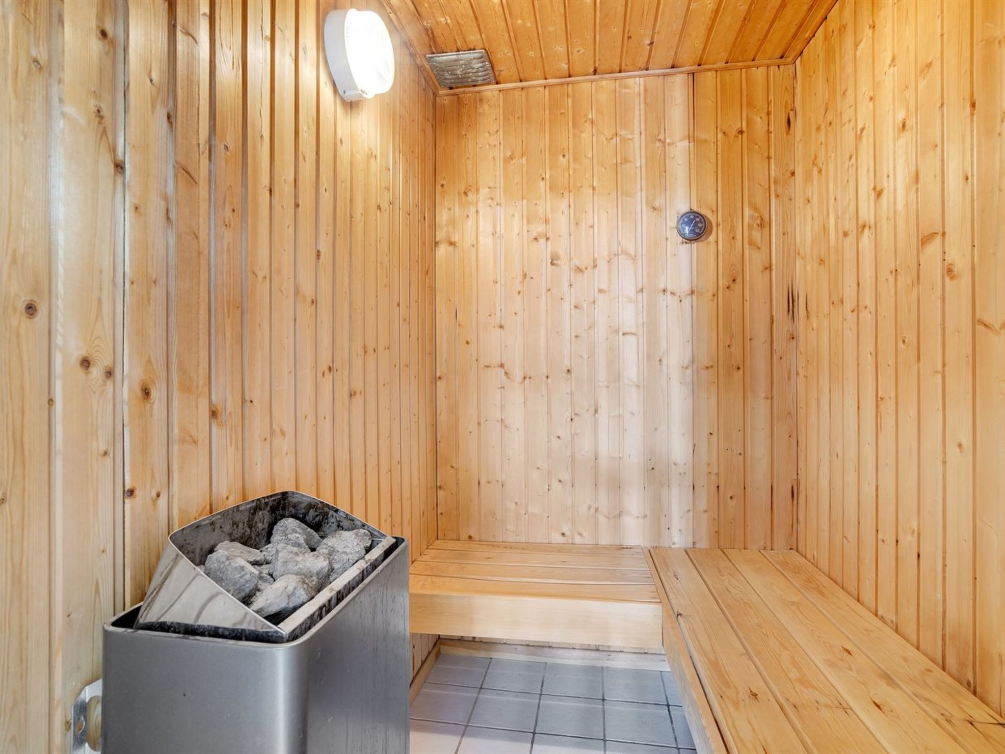 Una sauna con paredes de madera y un banco.