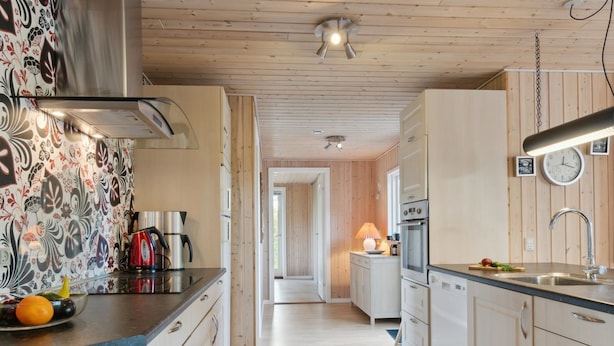 A modern kitchen with wooden cabinets, stainless steel appliances, and a patterned backsplash. - "Letizia" - 700m from the sea by Interhome (Hals)