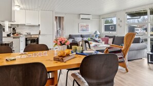 Un espace de vie moderne et bien éclairé, comprenant une cuisine, un coin repas et un espace salon.