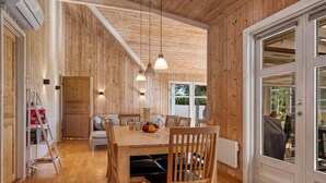 Un intérieur en bois comprenant un coin repas, un canapé et une échelle.