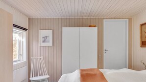 A bedroom with a bed, a chair, a wardrobe, a picture on the wall, and a window. - "Rudi" - 450m from the sea by Interhome (Hals)