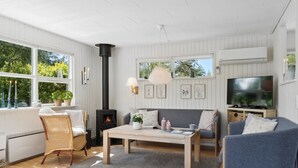 Ein gemütliches Wohnzimmer mit Kamin, einer Couch, einem Couchtisch und einem Fernseher.