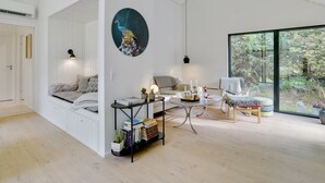 Ein modernes Wohnzimmer mit einem großen Fenster, einem runden Gemälde und einer gemütlichen Sitzecke.