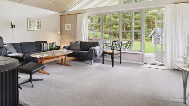 A spacious living room with a high ceiling, a large window offering a view of the outdoors, a sofa, a coffee table, and a chair. - "Henny" - 1.5km from the sea by Interhome (Hals)