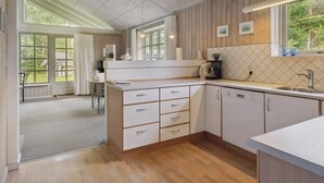 A modern kitchen with wooden cabinets, a countertop, and a window overlooking a garden. - "Henny" - 1.5km from the sea by Interhome (Hals)