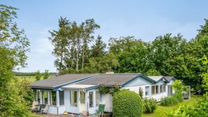 A single-story house with a covered patio, surrounded by lush greenery and trees. - "Lenard" - 400m from the sea by Interhome (Hals)