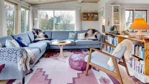 A cozy living room with a blue sofa, a wooden coffee table, and a bookshelf filled with books. - "Lenard" - 400m from the sea by Interhome (Hals)
