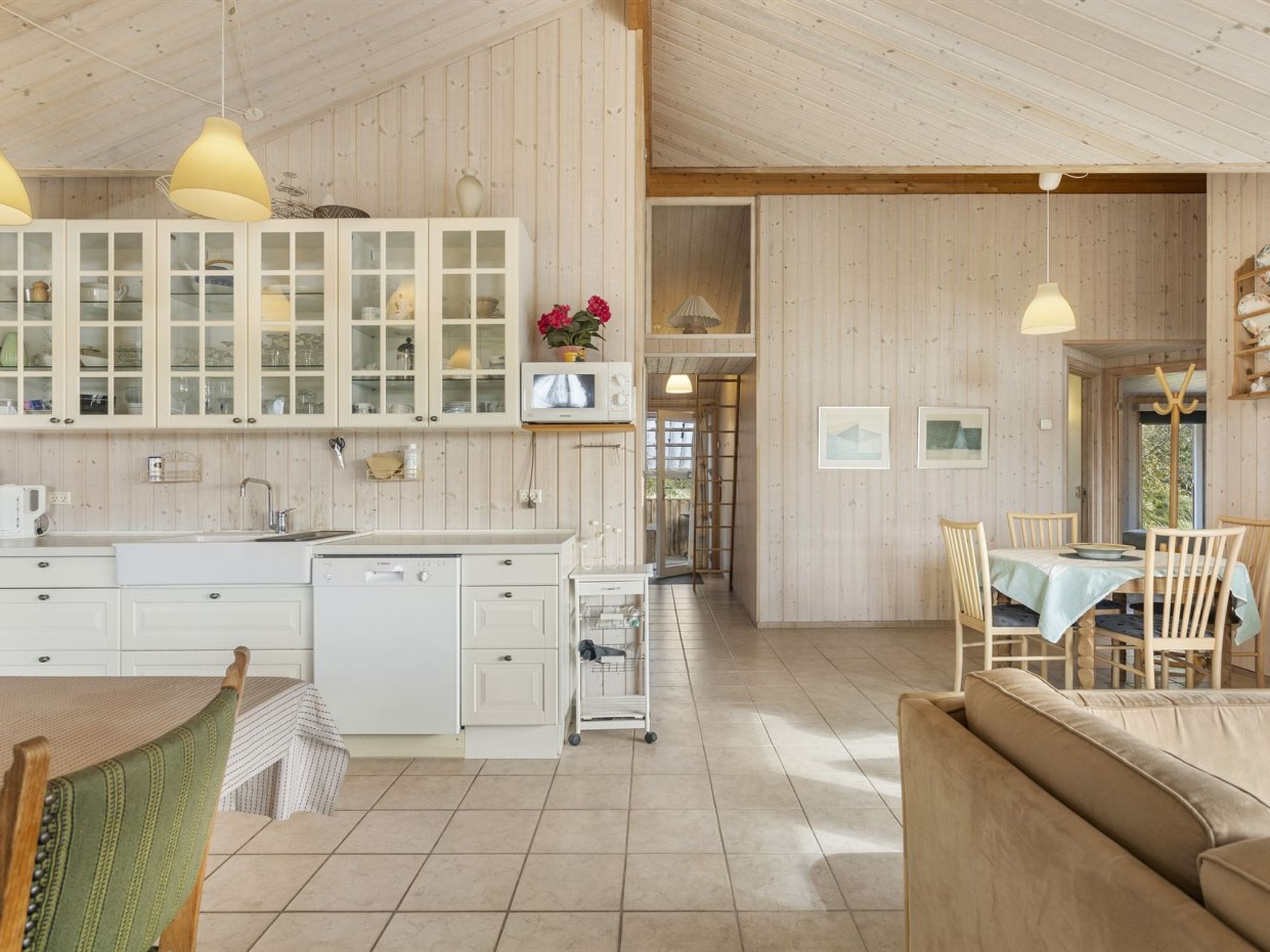 A spacious kitchen with a central island, white cabinetry, and pendant lighting.