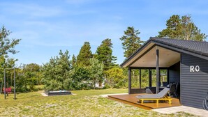 Een moderne buitenruimte met een overdekte zithoek, een schommel en een zwembad.